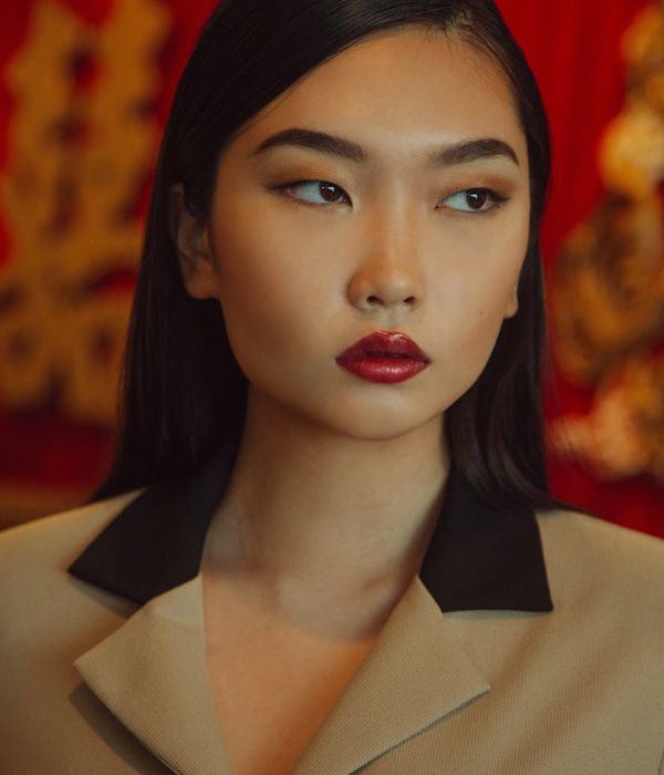 Serene woman focusing her gaze forward in a dark room.